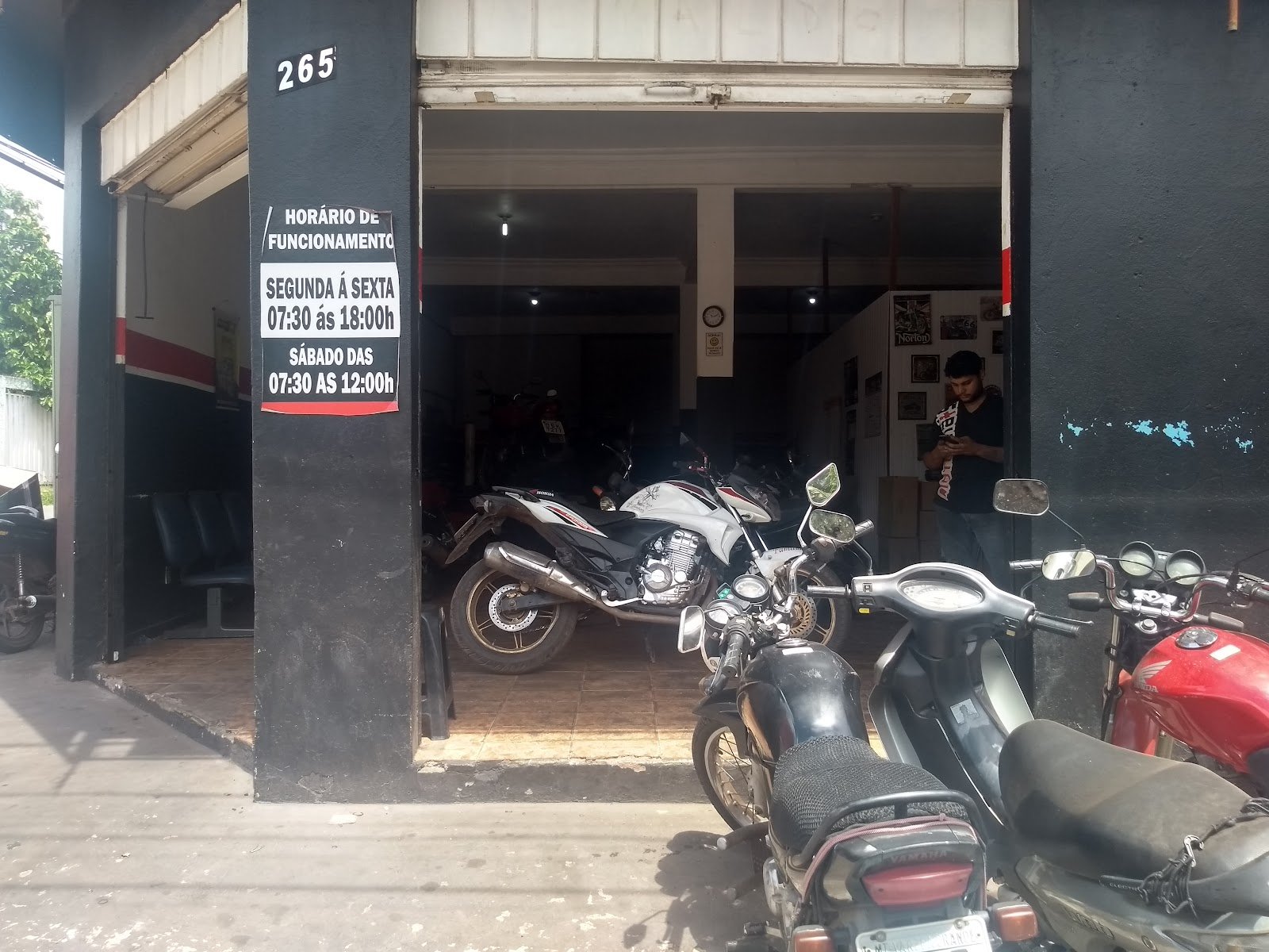 Entrada da oficina com a placa de horário de funcionamento