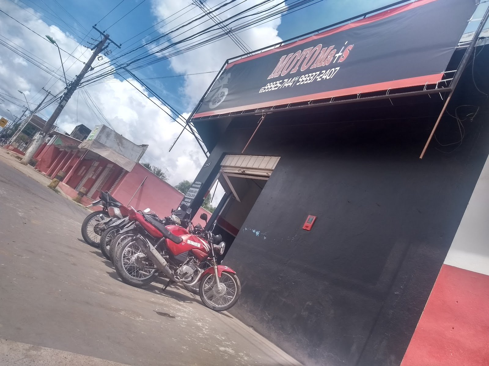Fachada da Moto Mais vista da rua, com motos estacionadas na frente