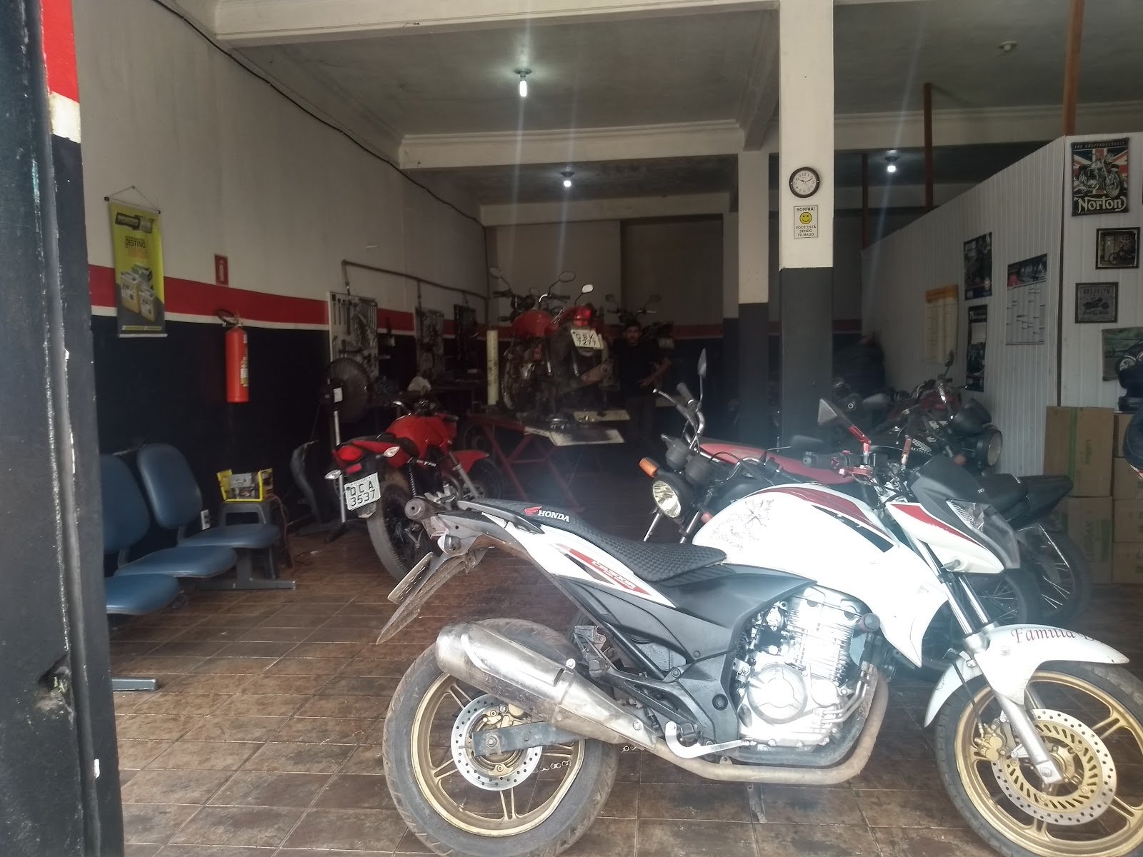 Interior da oficina com motos em manutenção e área de espera